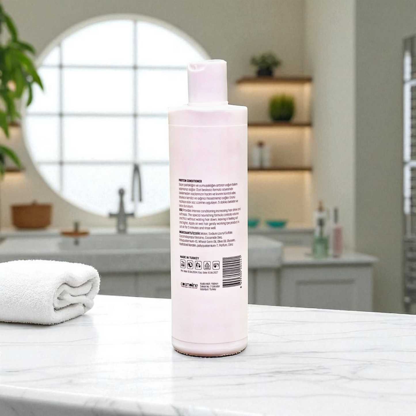 Pink bottle with text on a bathroom counter with a blurred background