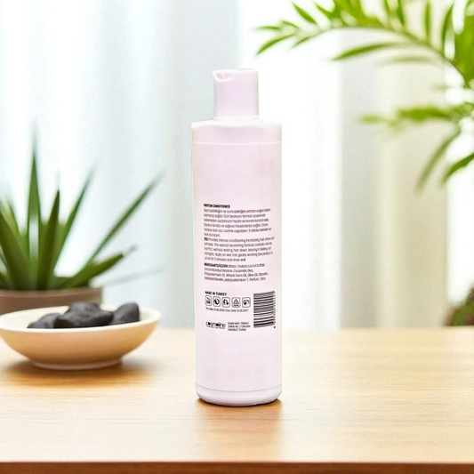 White bottle with pink label on a wooden surface with plants in the background