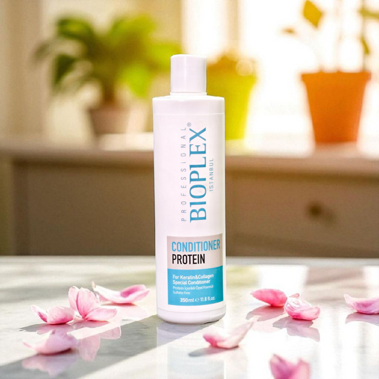 Bioplex Protein Conditioner bottle on a surface with pink petals and plants in the background